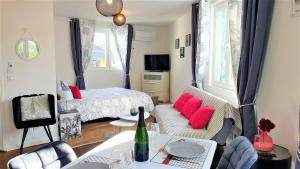 sala de estar con cama y sofá con almohadas rojas en Petit Ecrin à migennes balcon-gare-clim en Migennes