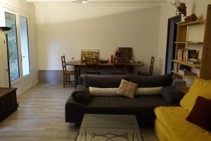 a living room with a couch and a table at Maison 8 personnes in Mézos