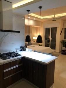 a kitchen with a stove and a bed in a room at Elysium Tower Studio Apartments with Centaurus View, Islamabad by LMY in Islamabad