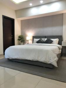 a bedroom with a large bed with a white bedspread at Elysium Tower Studio Apartments with Centaurus View, Islamabad by LMY in Islamabad