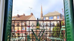 vistas a un balcón con mesa y a un edificio en Petit Ecrin à migennes balcon-gare-clim en Migennes