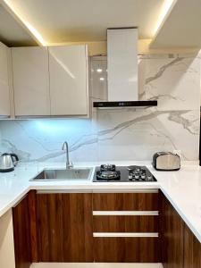 a kitchen with a sink and a stove at Elysium Tower Studio Apartments with Centaurus View, Islamabad by LMY in Islamabad