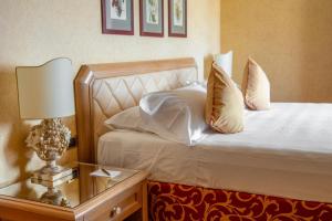 een slaapkamer met een bed en een tafel met een lamp bij Park Hotel Villa Ariston in Lido di Camaiore