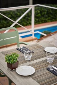 a table with plates and glasses and a plant on it at Catalonia Bristol in Sant Andreu de la Barca