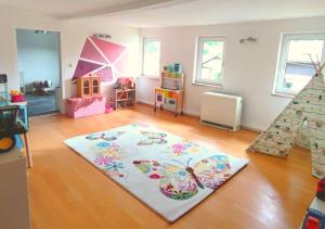a living room with a rug on a wooden floor at Ferienhaus Eden Frankenblick in Mengersgereuth-Hämmern