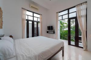 een witte slaapkamer met een bed en grote ramen bij Riverside Pool Villa - Nature Escape - Chiang Mai in Ban Don
