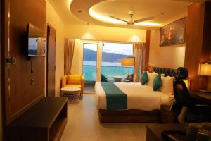 a hotel room with a bed and a view of the ocean at Sea Deck in Port Blair