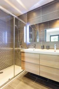 La salle de bains est pourvue d'une douche et d'un lavabo. dans l'établissement Chez Robert - luxueuse villa à proximité des plages avec une piscine privée, à La Grande Motte