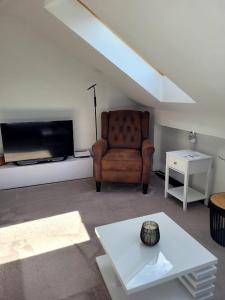 a living room with a chair and a flat screen tv at gemütliche Ferienwohnung in Burgstaedt