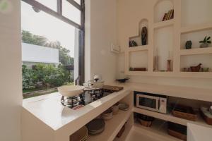 een keuken met een aanrecht met een magnetron en een raam bij Riverside Pool Villa - Nature Escape - Chiang Mai in Ban Don