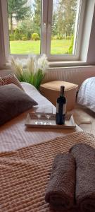 a bed with two glasses and a bottle of wine at Domek Karłowo u Eli in Sierakowice