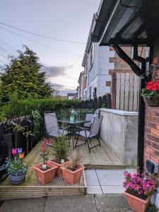 a patio with a table and chairs and potted plants at Máiréad - newly refurbished property in Gaeltacht Quarter in Belfast