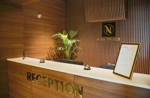 a reception desk with a sign that reads reception at Nina Palace Hotel in Tbilisi City