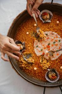 uma pessoa está comendo comida em uma panela em Lago Resort Menorca - Casas del Lago Adults Only em Cala'n Bosch