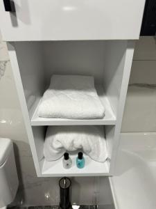 biała szafka z ręcznikami i łóżko w łazience w obiekcie Gürtürkler Suit Otel w Muş