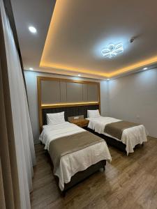 Zimmer mit 2 Betten und einer Decke in der Unterkunft Gürtürkler Suit Otel in Muş