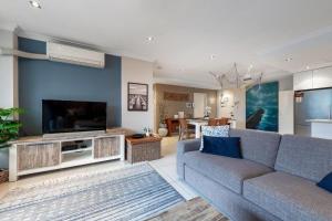 a living room with a couch and a large television at SWITCH OFF! Chill out and have fun on the lakeside in The Entrance