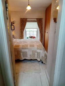 Schlafzimmer mit einem Bett und einem Fenster in der Unterkunft Tanners Cottage in Cockermouth