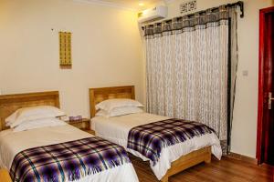 um quarto com 2 camas e uma janela em The Little Home em Arusha