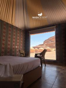a bedroom with a bed and a view of the desert at Nasa desert luxury camp in Wadi Rum