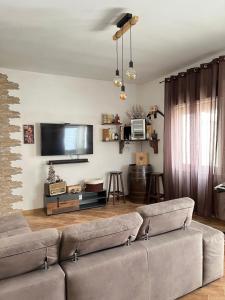 sala de estar con sofá y TV de pantalla plana en Casa Farinelli, en Campobello di Mazara