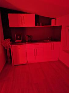 Spa Hera : مطبخ احمر مع دواليب حمراء في الغرفة