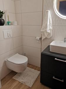 ein weißes Bad mit einem WC und einem Waschbecken in der Unterkunft Spa Hera 