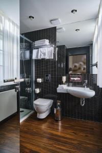a bathroom with a toilet and a sink and a shower at Perla Hotel in Prague