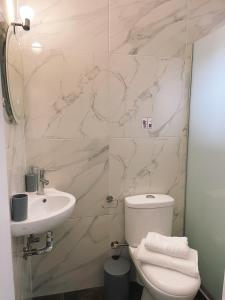 a bathroom with a white toilet and a sink at By the Sea Luxury Apartment in Nikiti