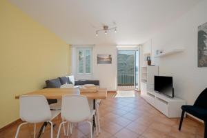 a dining room and living room with a table and chairs at Brissago Lake Apartment in Brissago