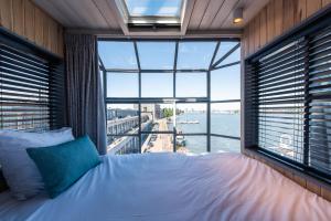 a bedroom with a bed and a large window at Numa Amsterdam The Crane in Amsterdam