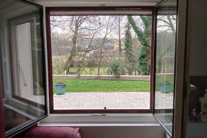 ein offenes Fenster mit Blick auf einen Hof in der Unterkunft Au coeur de La Dombes in Saint-Paul-de-Varax