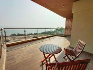 a balcony with a table and chairs and a view of the ocean at Stelliam's Chic 2 Bhk Sea View Apartment in Goa in Panaji