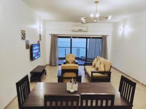 a living room with a table and chairs and a couch at Stelliam's Chic 2 Bhk Sea View Apartment in Goa in Panaji