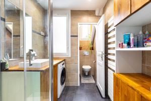 a bathroom with a sink and a washing machine at GuestReady - Modern stay near Atelier des Lumières in Paris