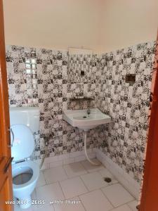 La salle de bains est pourvue d'un lavabo et de toilettes. dans l'établissement Abhi house, à McLeod Ganj