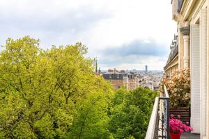 a balcony with trees and a view of a city at GuestReady - Modern stay near Atelier des Lumières in Paris