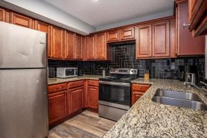 a kitchen with wooden cabinets and a stainless steel refrigerator at NEW ENTIRE PLACE COZY QUIET 2b2b TOWNHOUSE SP1261 in Norcross