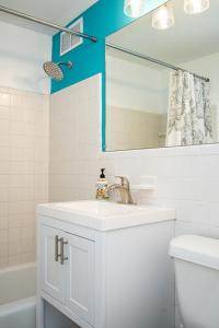 a white bathroom with a sink and a mirror at Downtown! 5 Beds! Onsite Parking! City View! New Renovated! LM1806 in Atlanta