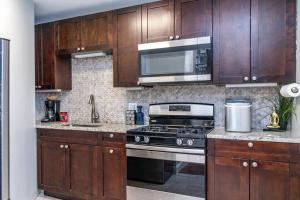 a kitchen with wooden cabinets and a stove and microwave at Downtown! 2BD City view Onsite Parking King LM809 in Atlanta