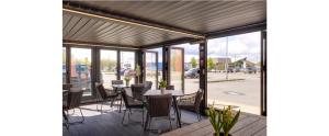 a patio with tables and chairs and windows at ibis budget Derby in Derby