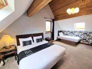 een slaapkamer met een groot bed en een bank bij Lbtie Lodge with Two Private Hot Tubs - Fife - Loch Leven - Lomond Hills in Kelty