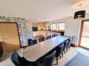 een keuken en eetkamer met een tafel en stoelen bij Lbtie Lodge with Two Private Hot Tubs - Fife - Loch Leven - Lomond Hills in Kelty