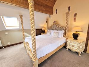 a bedroom with a four poster bed and a lamp at Lbtie Lodge with Two Private Hot Tubs - Fife - Loch Leven - Lomond Hills in Kelty