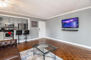 ein Wohnzimmer mit einem Sofa und einem TV an der Wand in der Unterkunft ENTIRE CONDO! Downtown! 24 Concierge! 9B in Atlanta