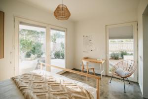 a bedroom with a bed and a desk and a chair at Casa 7 boxes - amazing villa with heated pool in Comporta +76 photos