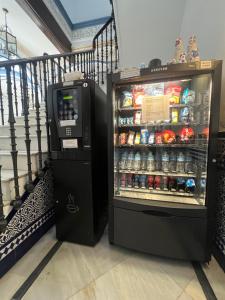 a vending machine and a drink cooler next to a staircase at Casa Palacio Don Pedro in Seville