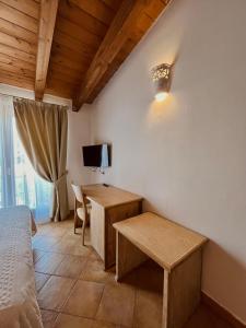 a bedroom with a bed and a table and a desk at Hotel La Borgata in San Pantaleo