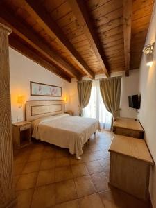 a bedroom with a bed and a large window at Hotel La Borgata in San Pantaleo