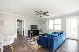 a living room with a blue couch and a ceiling fan at Center Downtown! King Bed! Private Balcony! PT8I in Atlanta +43 photos
